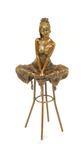 Een bronzen beeld van een zittende dame op barkruk