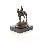 Een bronzen sculptuur van een paard met rijder