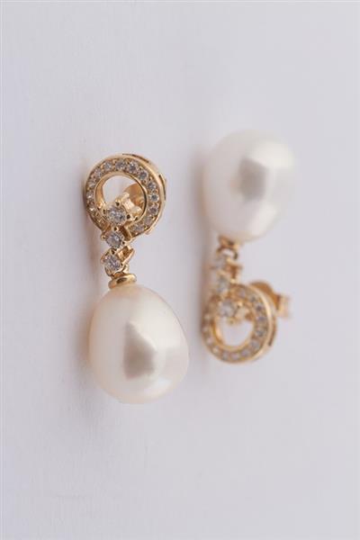 Grote foto gouden oorhangers met een parel en briljanten sieraden tassen en uiterlijk oorbellen