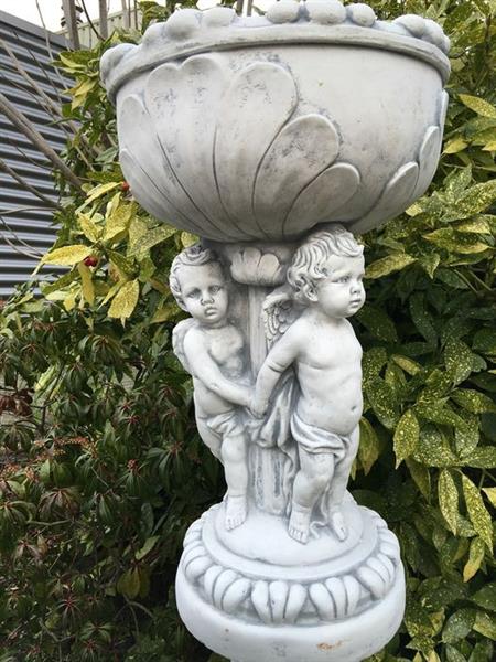 Grote foto prachtige zware bloempot vaas uit vol steen gedragen door engelen. tuin en terras tuindecoratie