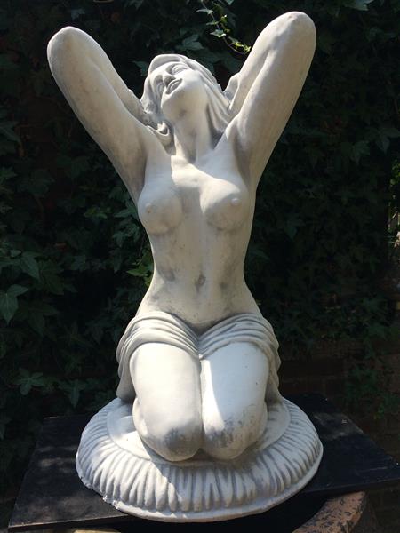 Grote foto mooi vol stenen beeld van een naakte knielende vrouw heel fraai tuin en terras tuindecoratie