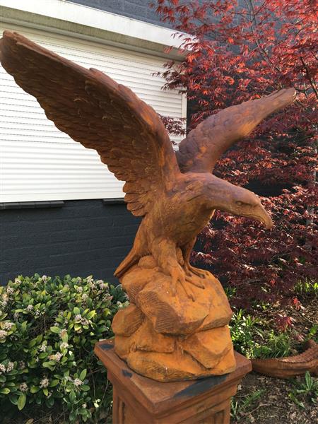 Grote foto zeer forse adelaar oxide steen in prooipakkende actie bruin op sokkel. tuin en terras tuindecoratie