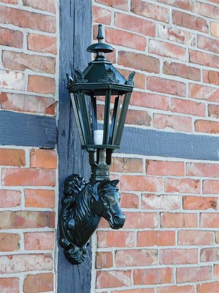 Grote foto prachtige buitenlamp met paardenhoofd donkergroen tuin en terras tuindecoratie