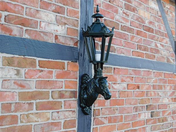 Grote foto prachtige buitenlamp met paardenhoofd donkergroen tuin en terras tuindecoratie
