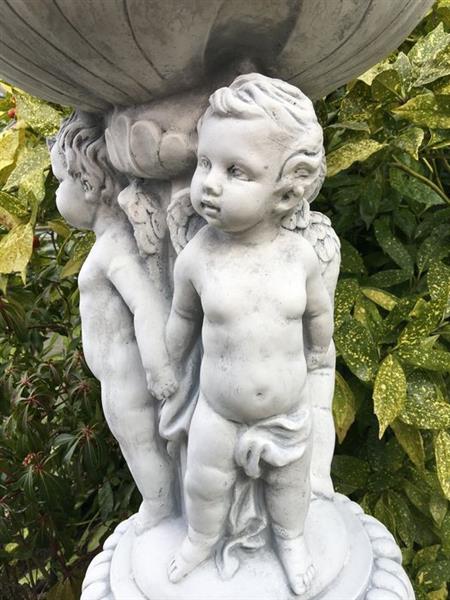 Grote foto prachtige zware bloempot vaas uit vol steen gedragen door engelen. tuin en terras tuindecoratie