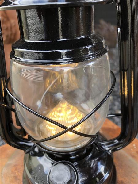 Grote foto een antiek uitziende olie storm lamp metaal zwart met led verlichting. tuin en terras verlichting