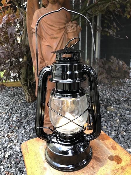 Grote foto een antiek uitziende olie storm lamp metaal zwart met led verlichting. tuin en terras verlichting