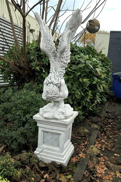 Grote foto zeer forse knielende engel met vleugels omhoog op grote sokkel zeer fors tuin en terras tuindecoratie