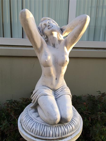 Grote foto mooi vol stenen beeld van een naakte knielende vrouw heel fraai tuin en terras tuindecoratie