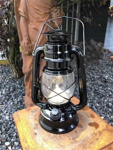 Grote foto een antiek uitziende olie storm lamp metaal zwart met led verlichting. tuin en terras verlichting