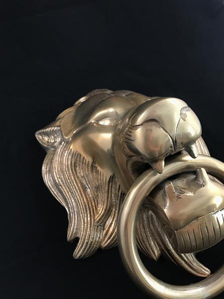 Grote foto een leeuwenkop gemaakt van aluminium in messing kleur als deurklopper tuin en terras tuindecoratie