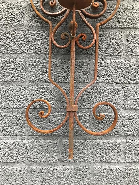 Grote foto fraai wandornament als een kaarshouder mooie decoratieve kandelaar tuin en terras tuindecoratie