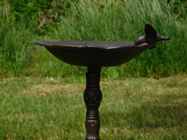 Grote foto fraai vogelbad op voet met leuk decoratief vogeltje op de rand van het bad gietijzer tuin en terras tuindecoratie