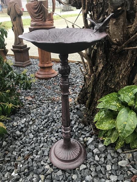Grote foto fraai vogelbad op voet met leuk decoratief vogeltje op de rand van het bad gietijzer tuin en terras tuindecoratie