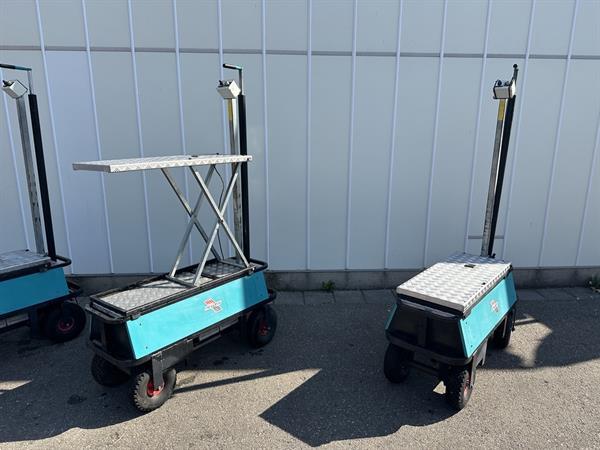 Grote foto berg elektrische transportwagen op luchtbanden met mechanische schaar. agrarisch tuinbouw