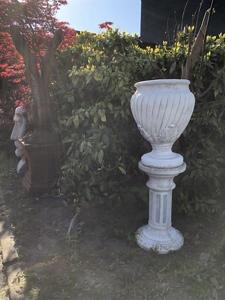 Grote foto grote vaas kruik bloembak op sokkel vol steen tuin en terras bloempotten