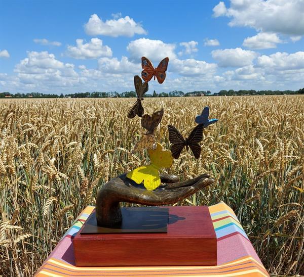 Grote foto zes vlinders in een hand symbolisch bronzenbeeld antiek en kunst beelden houtsnijwerken